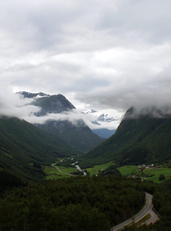 Beautiful scenery of a green landscape of mountains enveloped in fog